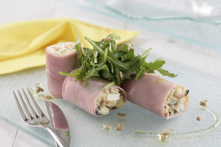 Rollitos de jamón rellenos de ensalada de arroz con tenedor al lado