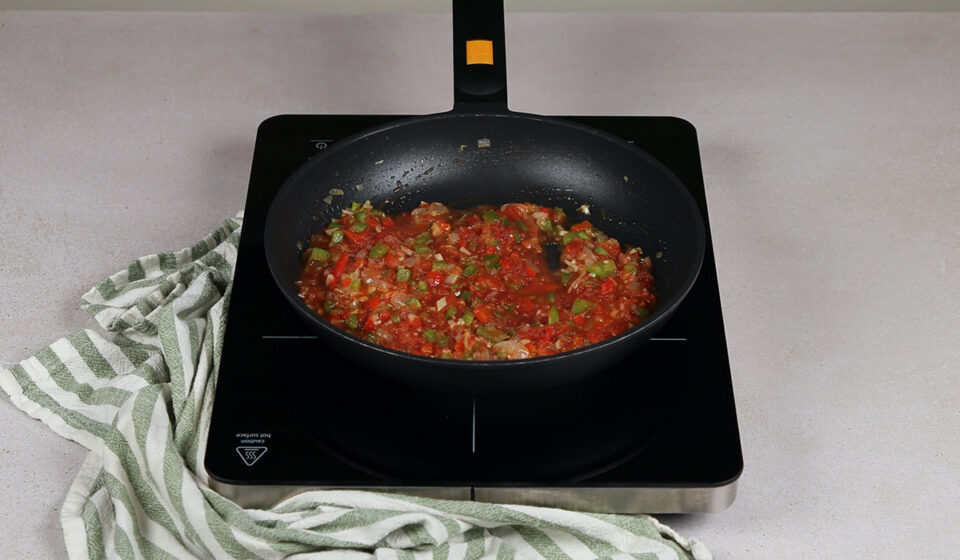 Añadir tomate a arroz con habas y alcachofas
